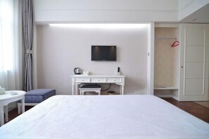 A hotel room with a bed, a desk, a television, and a wardrobe. - Jinyuwan Hotel (Dalian Lvshun University Town) (Dalian)
