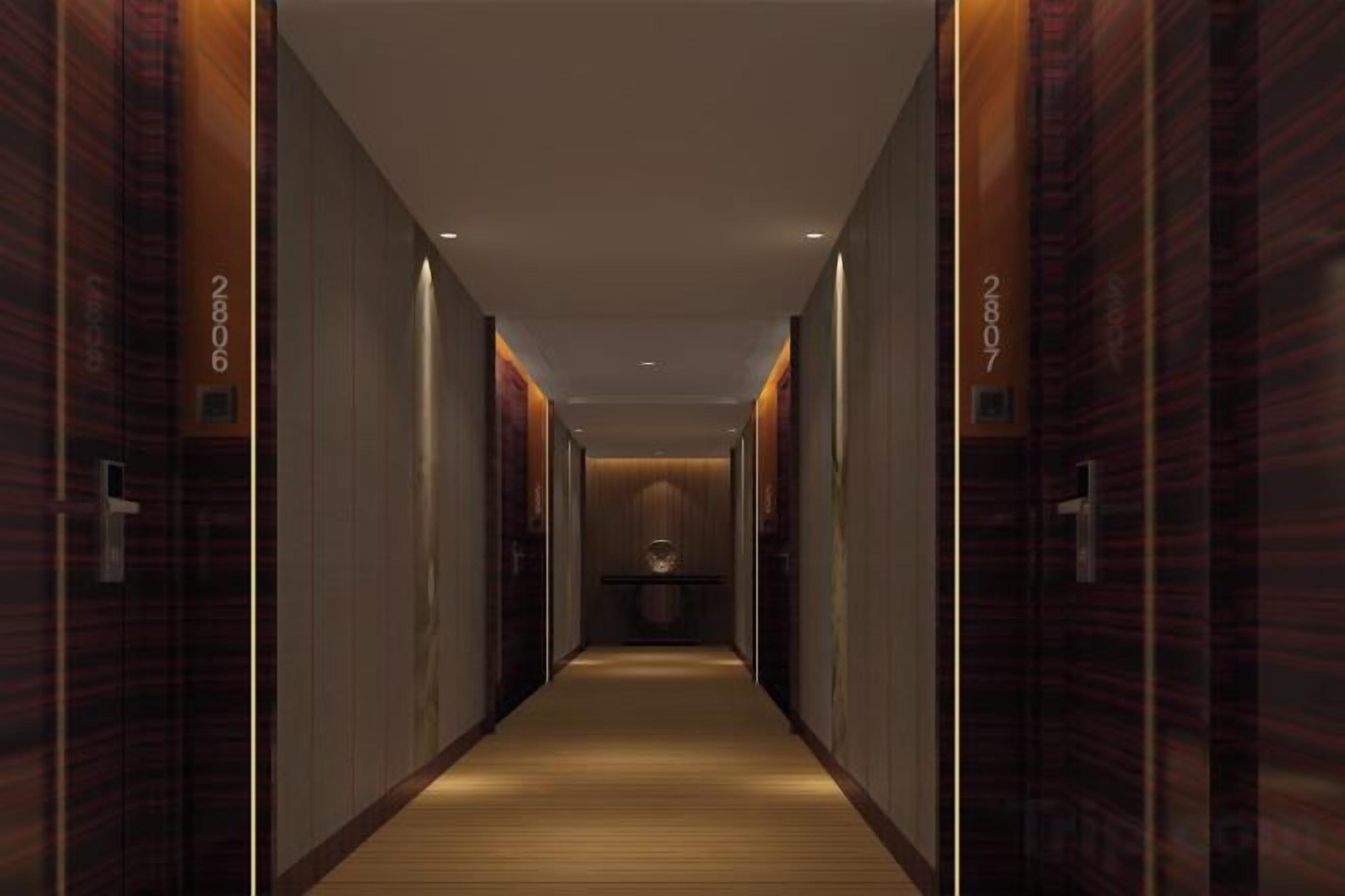 Un couloir avec des portes portant les inscriptions « HÔTEL » et « CHAMBRE 2807 », qui mène à une chambre.