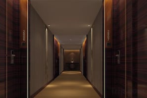 Un couloir avec des portes portant les inscriptions « HÔTEL » et « CHAMBRE 2807 », qui mène à une chambre.
