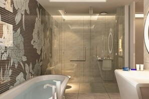 Un baño moderno con cabina de ducha de vidrio, bañera independiente y tocador con espejo.