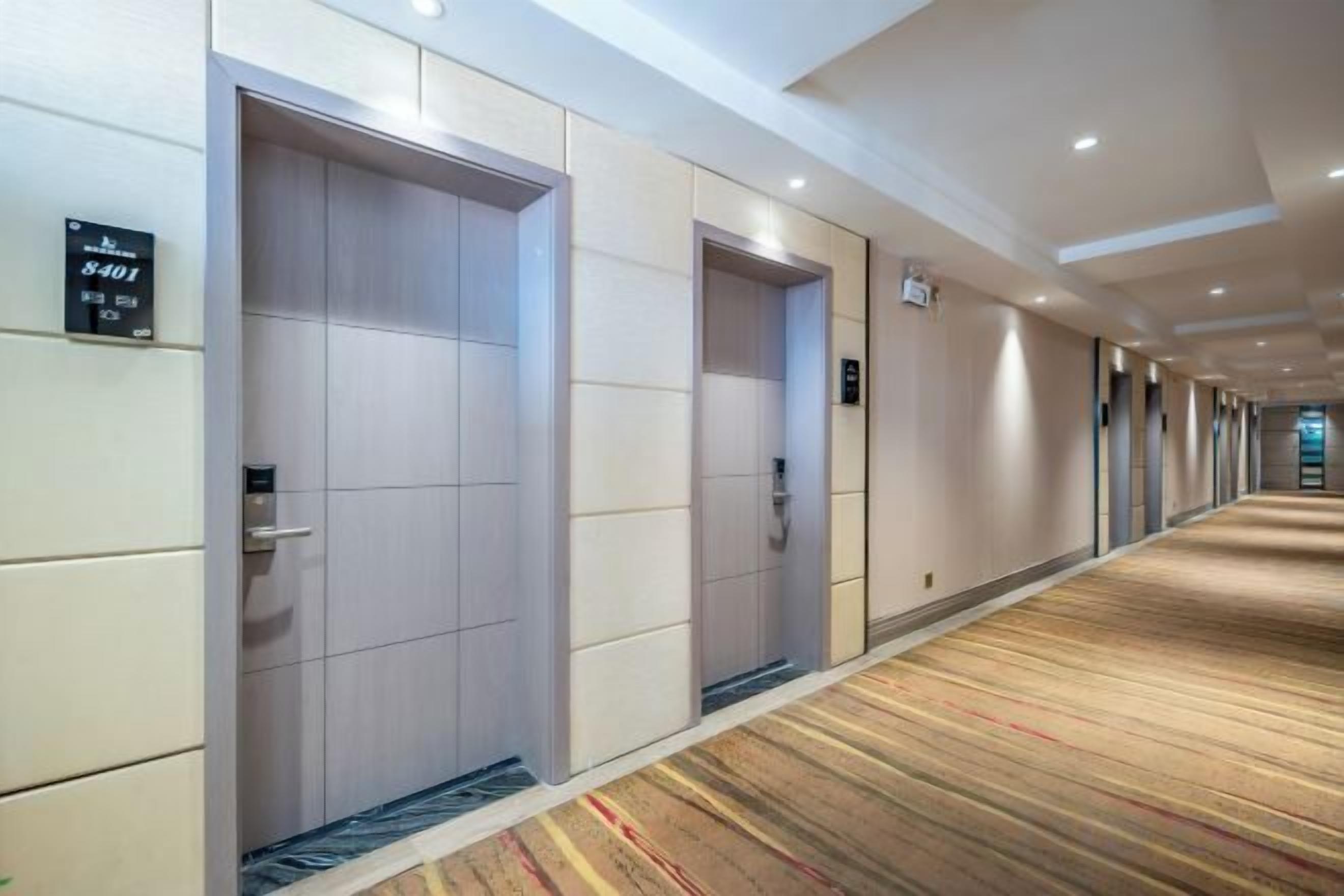 Un pasillo de hotel con dos puertas, cada una identificada con un número y un cartel que indica el nivel del piso.