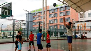 An indoor basketball court with a net, a basketball hoop, and a group of people playing. - Ibis Styles Shanghai Qingpu Sports Center Hotel (Shanghai)