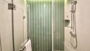 A modern shower enclosure with a glass door, a handheld showerhead, and a wall-mounted faucet. - Ibis Styles Shanghai Qingpu Sports Center Hotel (Shanghai)