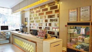 Zona de recepción con mostrador, computadoras y exhibición de productos.