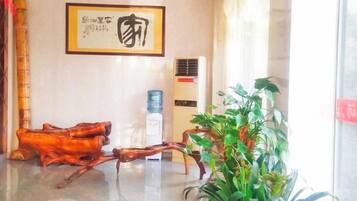 A lobby with a water dispenser, a framed artwork, and a plant.