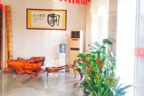 Un vestíbulo con dispensador de agua, una obra de arte enmarcada y una planta.