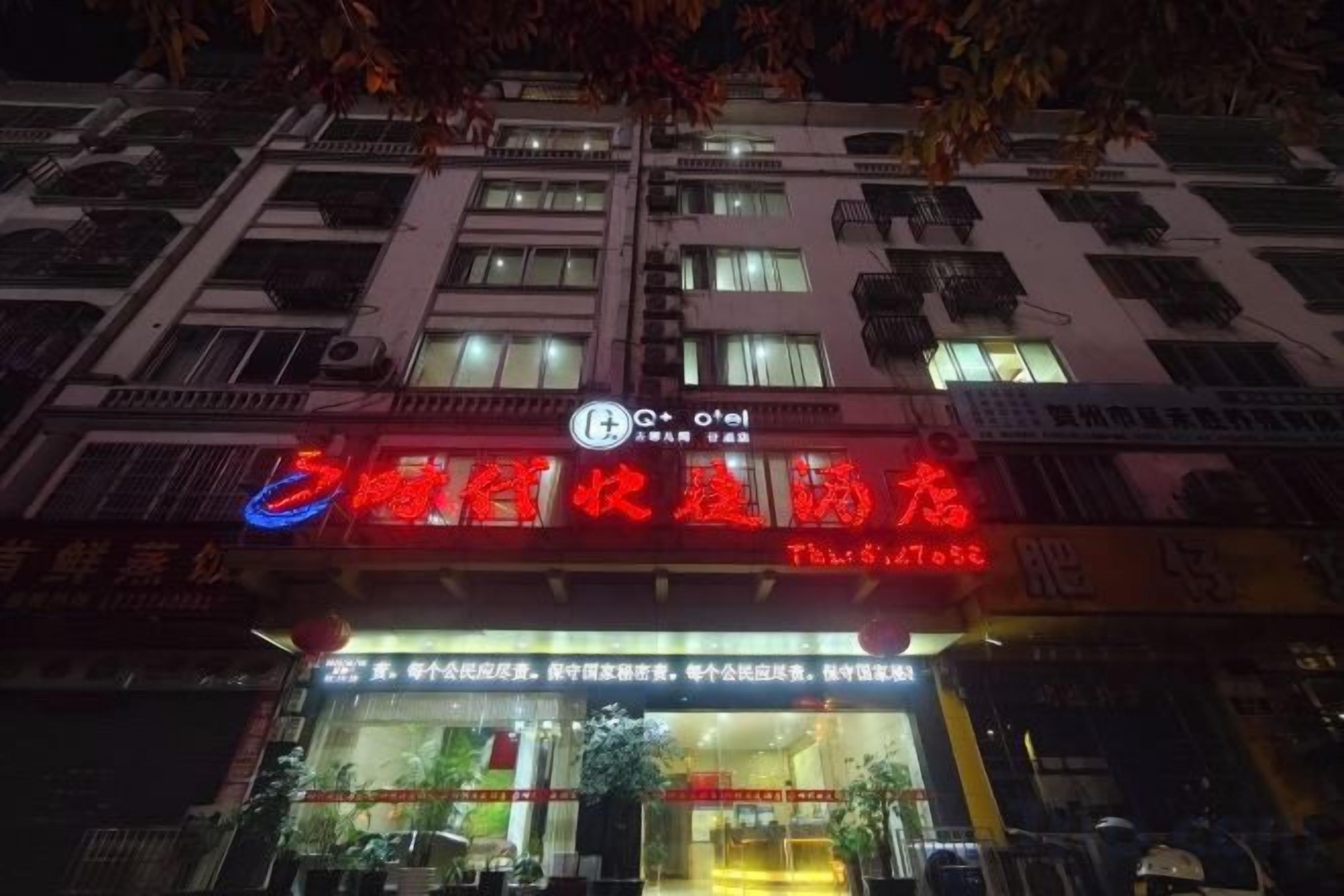 A building with illuminated signage, a visible entrance, and a clear view of the ground floor.