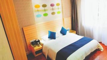 Una habitación de hotel con cama, mesita de noche, una obra de arte en la pared y una ventana con cortinas.