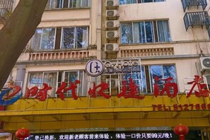 Un hotel con fachada amarilla y un letrero que indica que es un hotel.