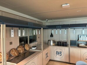A kitchen area with a stove, pots, and a display case with food items. - HanTing Hotel (Beijing New China International Exhibition Center) (Beijing)