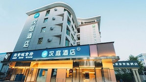 A hotel with a modern facade, a visible entrance, and signage indicating a restaurant and a spa.