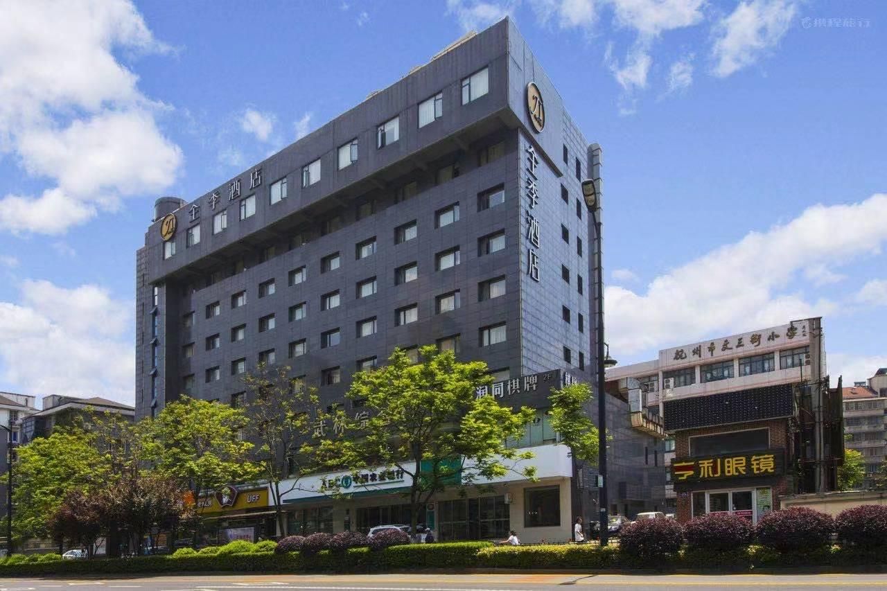 A multi-story hotel with a modern design, featuring a prominent logo on the facade, a flat roof, and a series of windows.