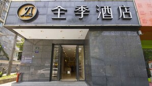 The entrance to a hotel with a modern facade and a sign indicating it is a hotel. - Ji Hotel (Hangzhou)