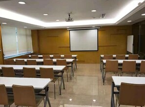 A conference room with tables and chairs arranged for a meeting. - Ji Hotel (Hangzhou)