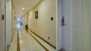 A hotel hallway with a long corridor, doors on the right, and a trash bin in the center. - Zhuoshang Boutique Hotel (Hangzhou)