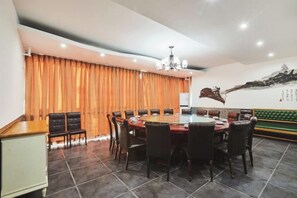 Un coin repas avec une table ronde, des chaises et un lustre.