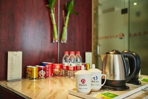 A hotel reception area with a wooden wall, a menu stand, bottled water, canned drinks, and a coffee maker. - Zhuoshang Boutique Hotel (Hangzhou)