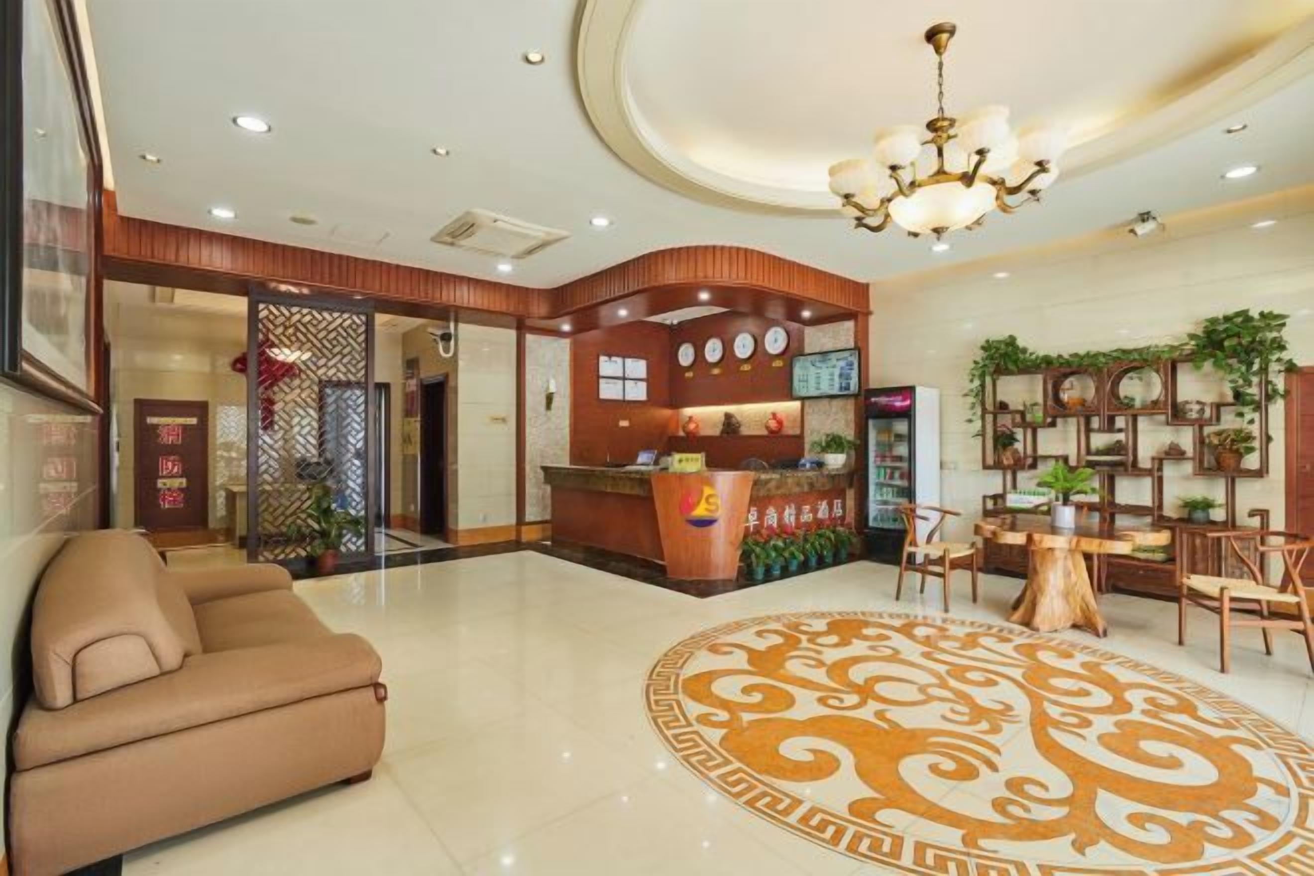 A hotel lobby with a reception desk, seating area, and decorative elements.