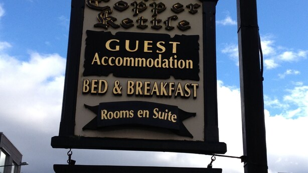 Ein Schild für eine Gastunterkunft, die Bed and Breakfast Leistungen anbietet, mit Hinweis auf verfügbare Zimmer in einer Suite.
