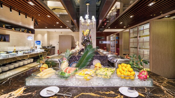 A buffet setup with various food items and a decorative centerpiece. - Gowin Hotel Hangzhou (Hangzhou)