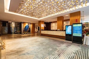 A hotel reception area with a modern design, a reception desk, and digital information displays. - Yunnan Weiju Golden Eagle Grand Hotel (Kunming Railway Station Shuangqiao Night Market Style Street) (Kunming)