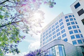 Un edificio moderno con facciata in vetro e struttura curva alla base.