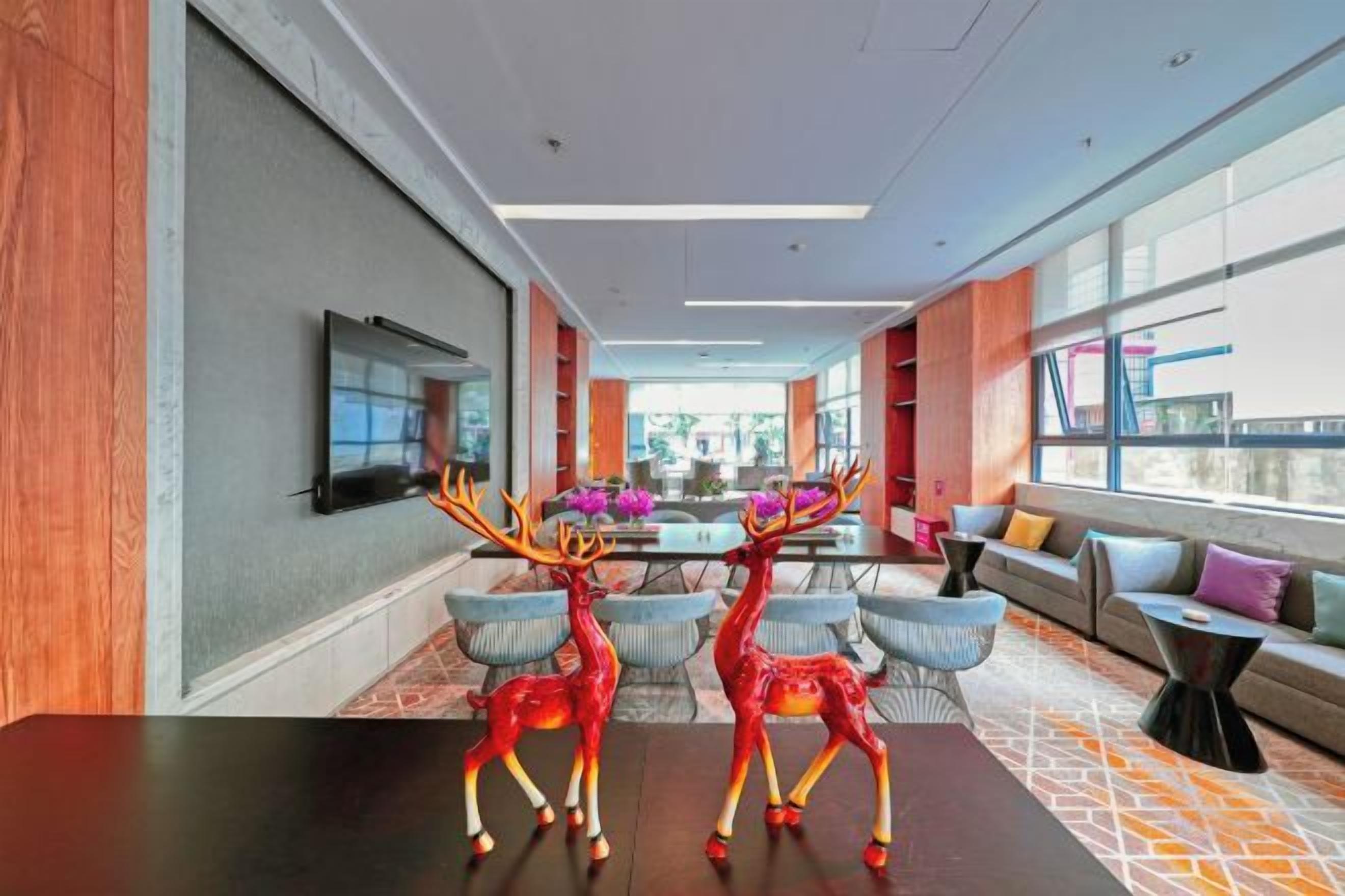 En modern hotellobby med en lång receptionsdisk, en sittgrupp och stora fönster med utsikt.