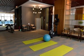 Une salle de sport équipée de matériel d’exercice, de tapis de yoga et d’un grand ballon de gymnastique.