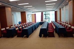 A conference room with rows of tables and chairs, large windows, and a carpeted floor. - Yunnan Weiju Golden Eagle Grand Hotel (Kunming Railway Station Shuangqiao Night Market Style Street) (Kunming)