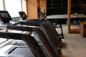 Una palestra con tapis roulant, attrezzature per esercizi e vista sull'esterno.