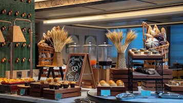 Mostrador de panadería con diversos productos horneados y una pizarra.