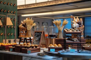 A bakery display with various baked goods and a chalkboard sign.