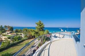 A balcony with a view of the sea, a pool, and surrounding greenery. - Villas F & B Summer Collection - Aegean Residence (Kassandra)
