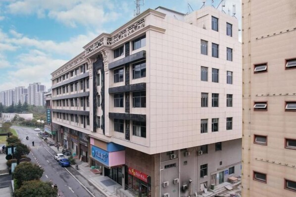 A multi-story building with a flat facade, several windows, and a ground-level entrance.