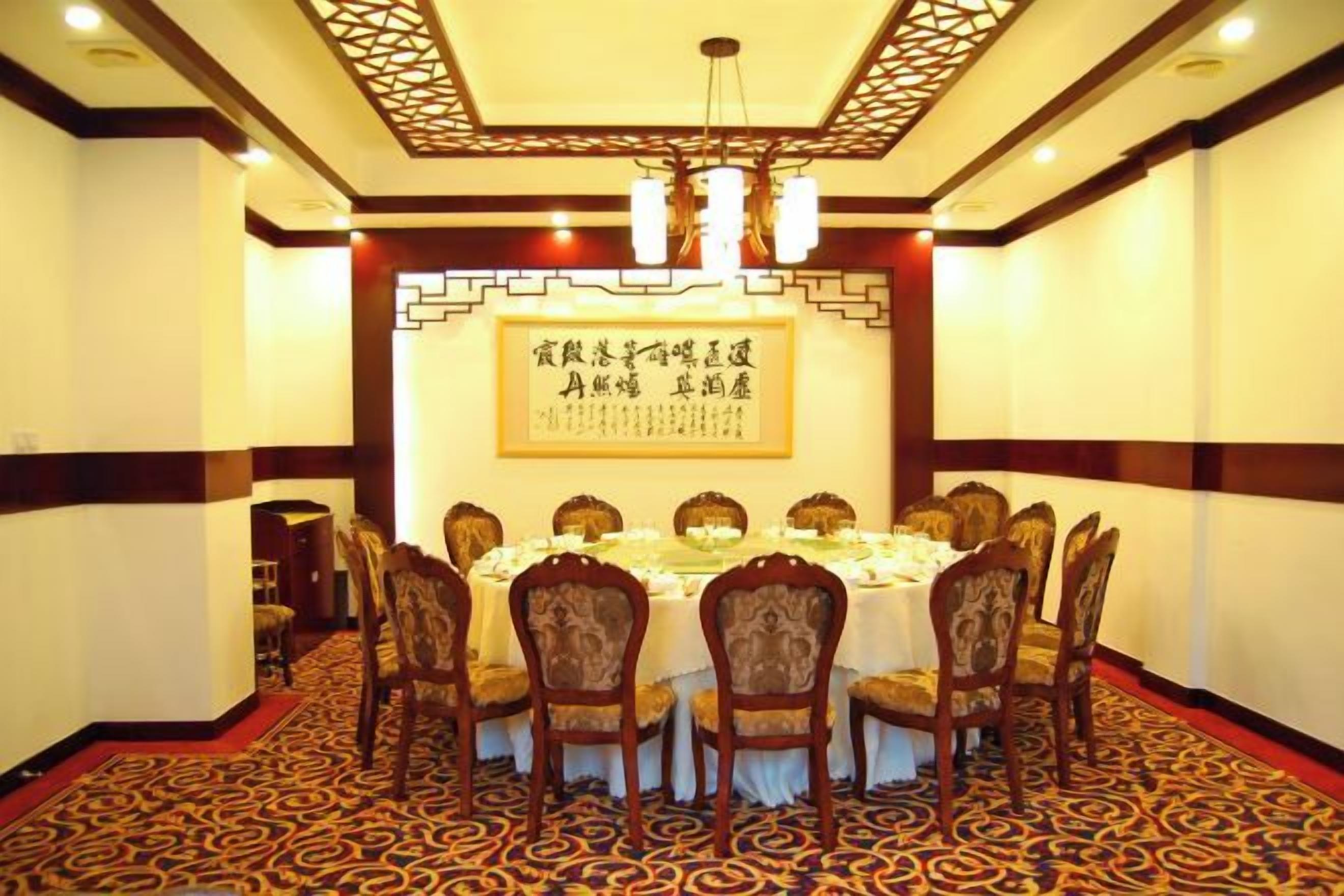 A conference room with a round table, chairs, and a decorative ceiling.