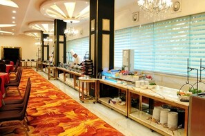 Un buffet est installé avec une longue table, des chaises et une variété de plats.