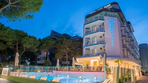 Ein Hotel mit Poolbereich, mehreren Balkonen und einem Schild mit der Aufschrift 'GRAND PLAZA'.