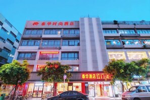 A multi-story hotel with a prominent red sign on the top. - Tai Hua Fashion Hotel(Shenzhen Huaqiang North Yannan subway station store) (Shenzhen)