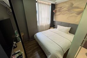 A hotel room with a bed, a television, a nightstand, and a window with curtains. - Tai Hua Fashion Hotel(Shenzhen Huaqiang North Yannan subway station store) (Shenzhen)