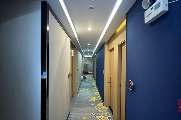A hotel hallway with carpeted floors, doors, and a ceiling light fixture. - Tai Hua Fashion Hotel(Shenzhen Huaqiang North Yannan subway station store) (Shenzhen)