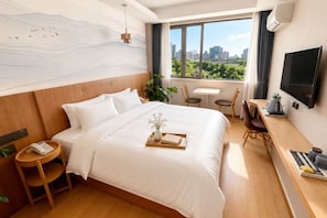 A hotel room with a bed, bedside table, TV, desk, and a view of the city.