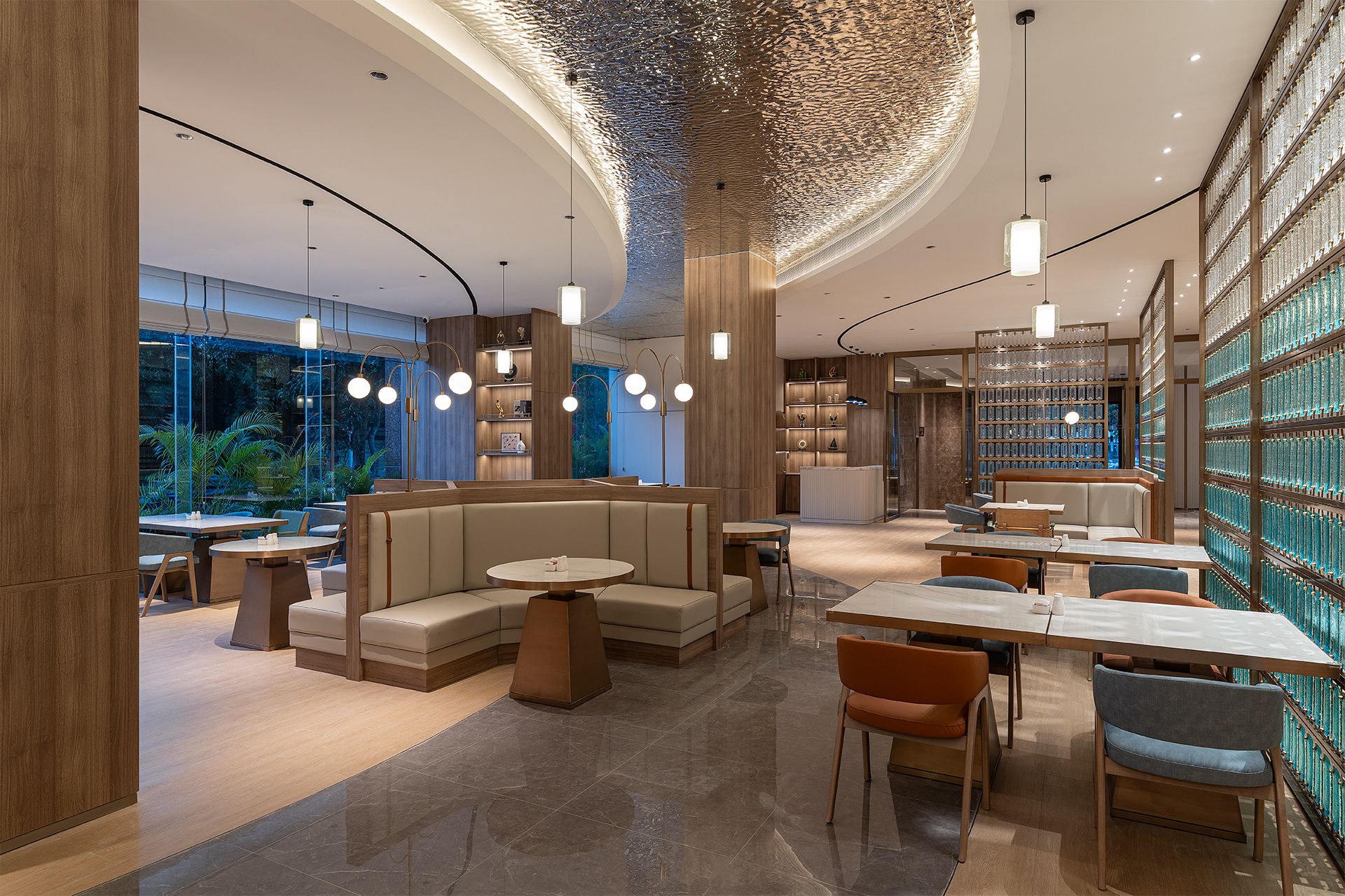 A modern interior with seating areas, tables, and a large glass display of items.