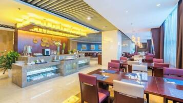 A modern hotel lobby with a central bar area, multiple seating arrangements, and a reception desk.