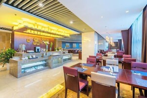 Un moderno vestíbulo de hotel con una barra central, diversas opciones de asientos y una recepción.
