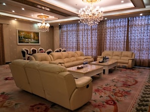Un salón amplio con un sofá seccional, una chaise lounge y una mesa de centro.