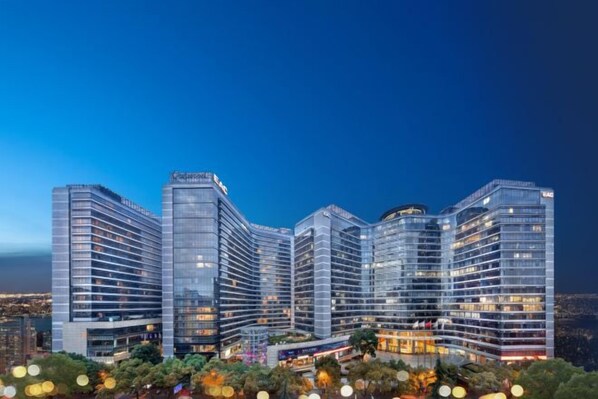 A multi-story hotel with a modern design, featuring a prominent glass facade and a series of balconies. - EAC Apartment Hotel (Hangzhou)
