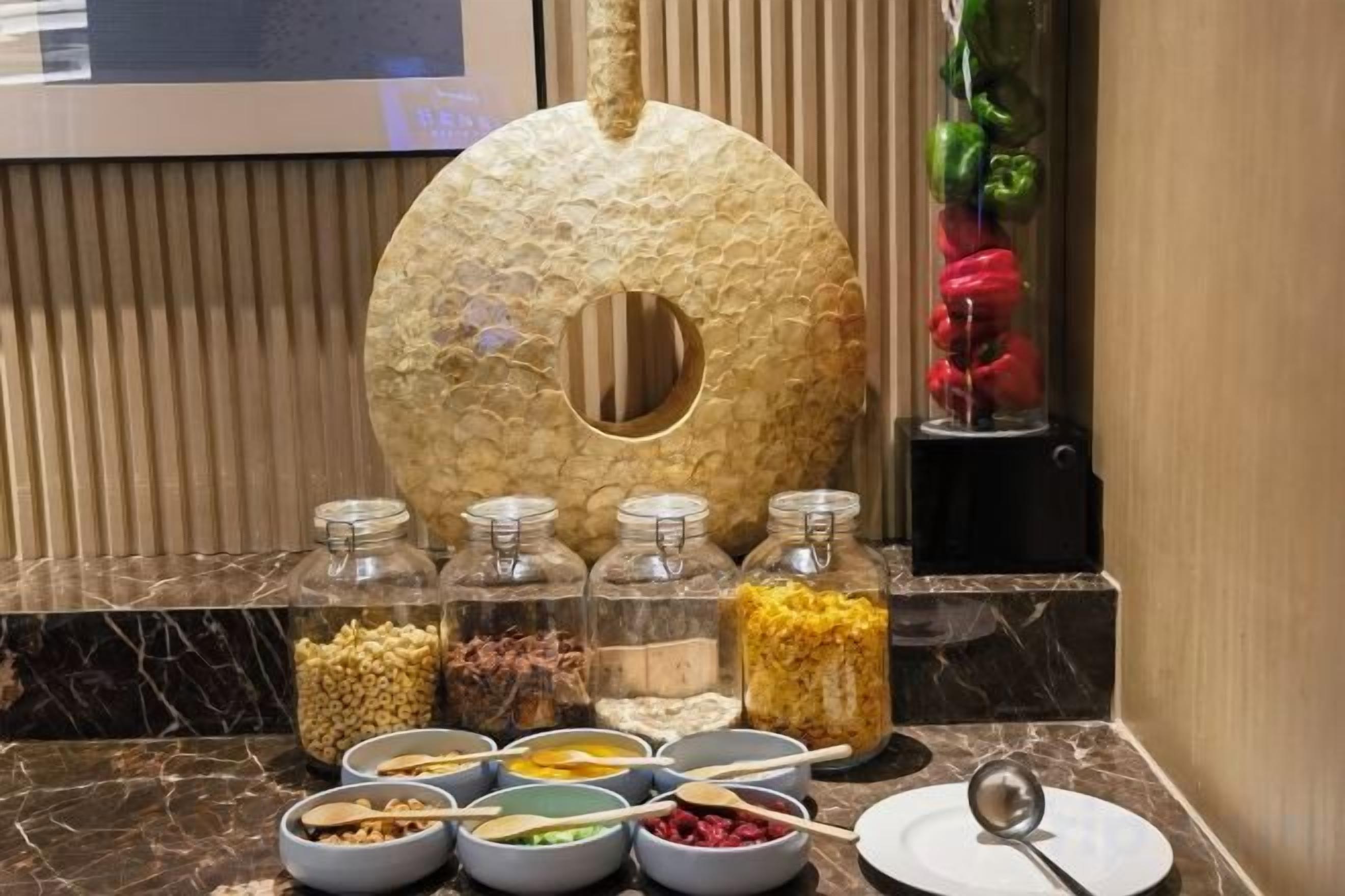 Disposição de buffet com diversos alimentos e um arranjo decorativo.