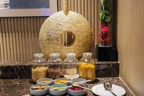 Un buffet proposant une variété de plats et agrémenté d’une pièce maîtresse décorative.