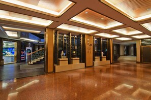 A spacious lobby with a polished floor, a staircase, and a reception area with a decorative wall. - Ningbo University Hotel (Ningbo)