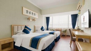 A hotel room with two beds, a desk, and a chair. - Ningbo University Hotel (Ningbo)